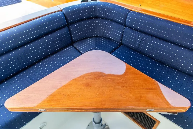 Chaser Yacht Photos Pics 2004 Hinckley Picnic Boat EP interior with blue cushioned seating and wooden table.