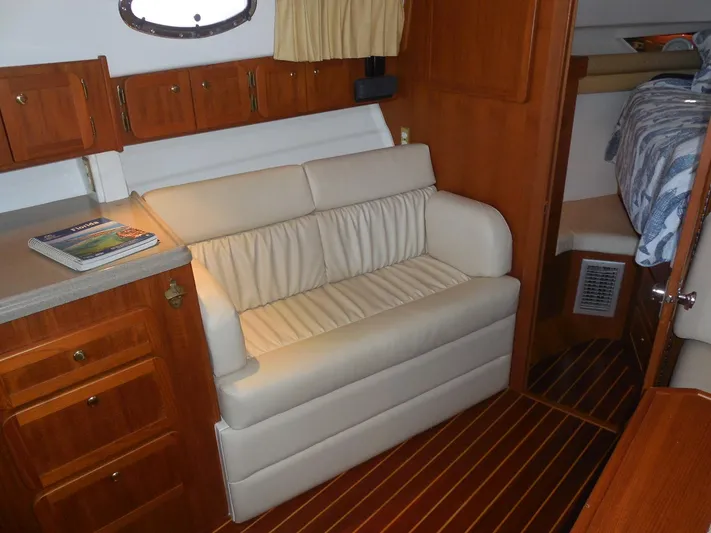  Yacht Photos Pics 2005 Stamas 370 Express cabin interior with beige sofa and wooden cabinetry.