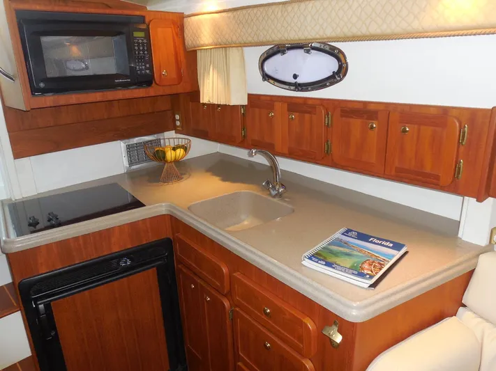  Yacht Photos Pics 2005 Stamas 370 Express yacht kitchen with wooden cabinets, microwave, and countertop sink.