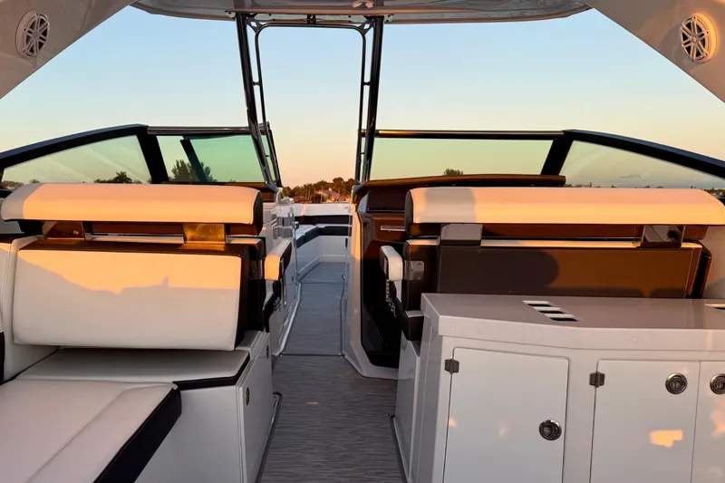 Yacht Photos Pics Interior of 2022 Monterey 385SS Super Sport boat at sunset, featuring luxurious seating.