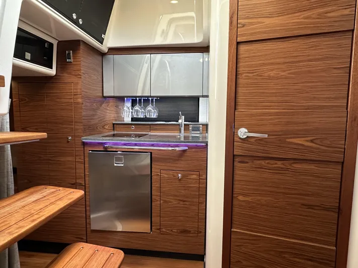 Isle Hope'n Yacht Photos Pics 2022 Boston Whaler 405 Conquest interior with modern kitchen and wooden cabinetry.