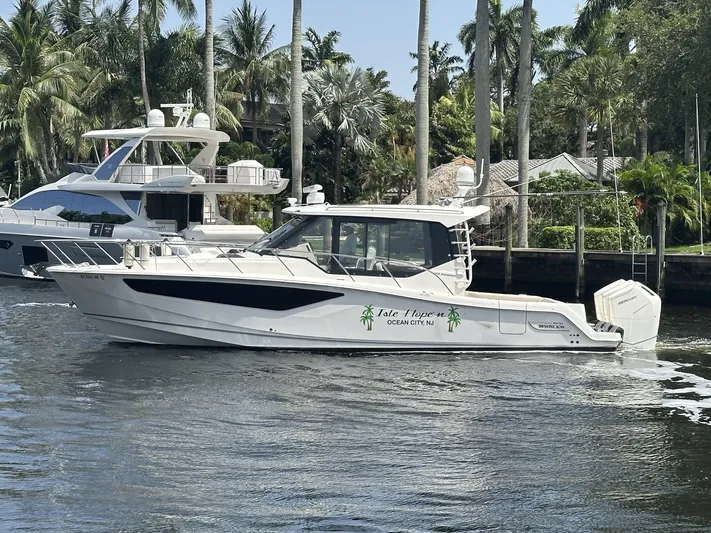 Isle Hope'n Yacht Photos Pics 2022 Boston Whaler 405 Conquest boat cruising on a sunny day near palm trees.