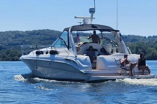  Yacht Photos Pics 2003 Sea Ray 410 Sundancer yacht cruising on a lake with passengers enjoying the sun.