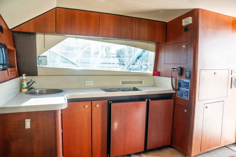  Yacht Photos Pics 2004 Luhrs 36 Convertible yacht kitchen with wood cabinetry, sink, and appliances.