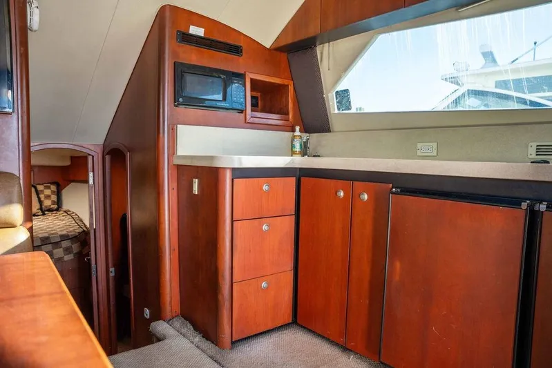  Yacht Photos Pics 2004 Luhrs 36 Convertible yacht interior with wooden cabinetry and compact kitchen area.