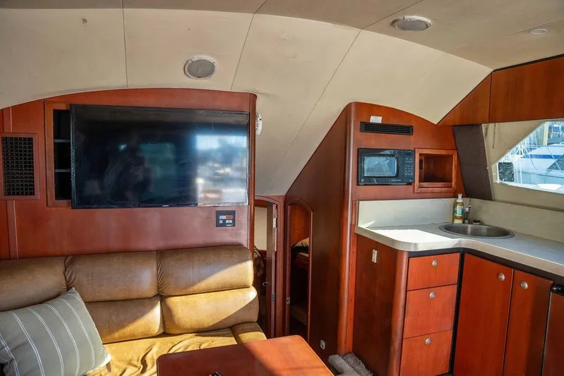  Yacht Photos Pics Interior of 2004 Luhrs 36 Convertible yacht with TV, sofa, and kitchenette.