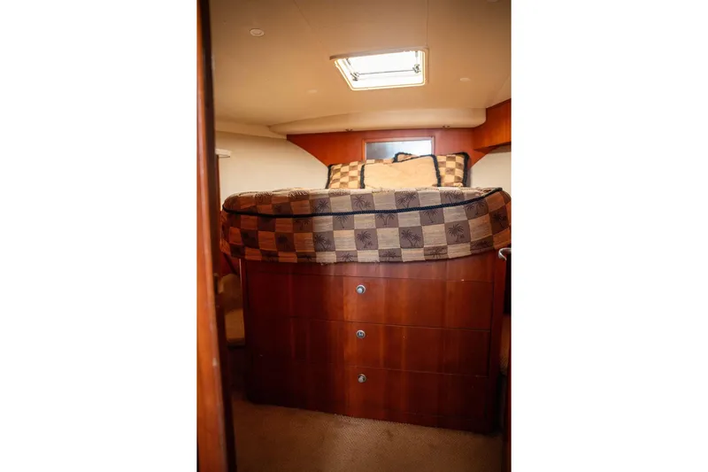  Yacht Photos Pics 2004 Luhrs 36 Convertible cabin interior with bed and wooden storage drawers.