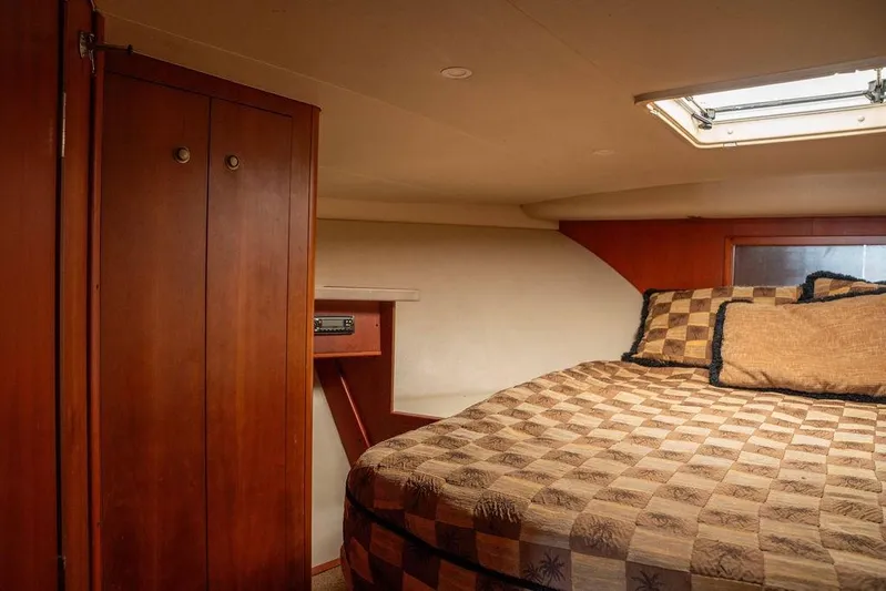  Yacht Photos Pics 2004 Luhrs 36 Convertible cabin interior with bed, wooden cabinets, and overhead hatch.