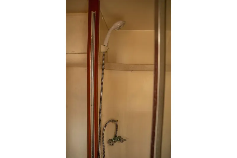  Yacht Photos Pics Shower area in 2004 Luhrs 36 Convertible boat, featuring handheld showerhead and beige interior.