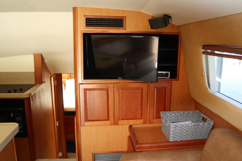  Yacht Photos Pics 2005 Luhrs 38 Convertible interior with TV, wooden cabinetry, and cozy seating area.