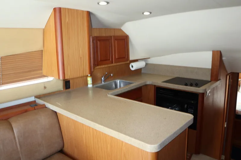  Yacht Photos Pics 2005 Luhrs 38 Convertible yacht kitchen with wood cabinetry and modern appliances.