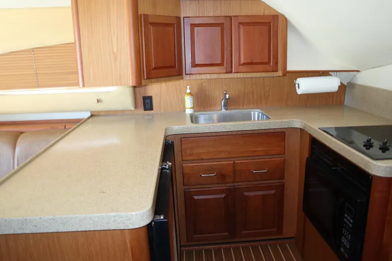  Yacht Photos Pics 2005 Luhrs 38 Convertible yacht kitchen with wooden cabinets and modern appliances.