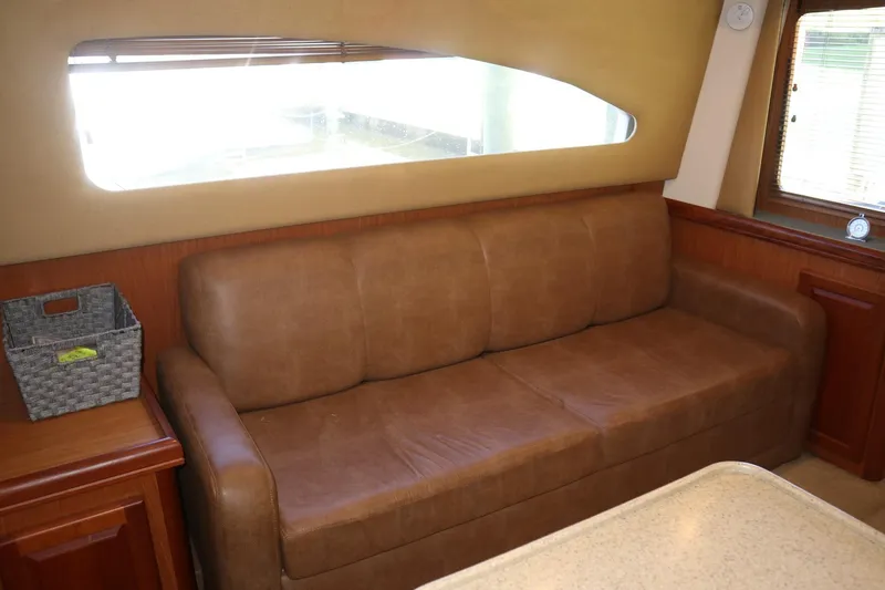  Yacht Photos Pics 2005 Luhrs 38 Convertible interior with brown leather sofa and window view.