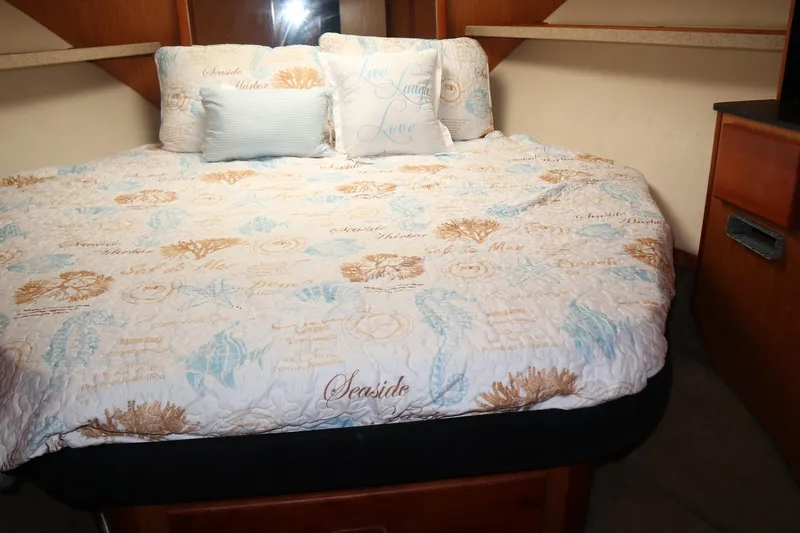  Yacht Photos Pics 2005 Luhrs 38 Convertible cabin with nautical-themed bedding and cozy pillows.