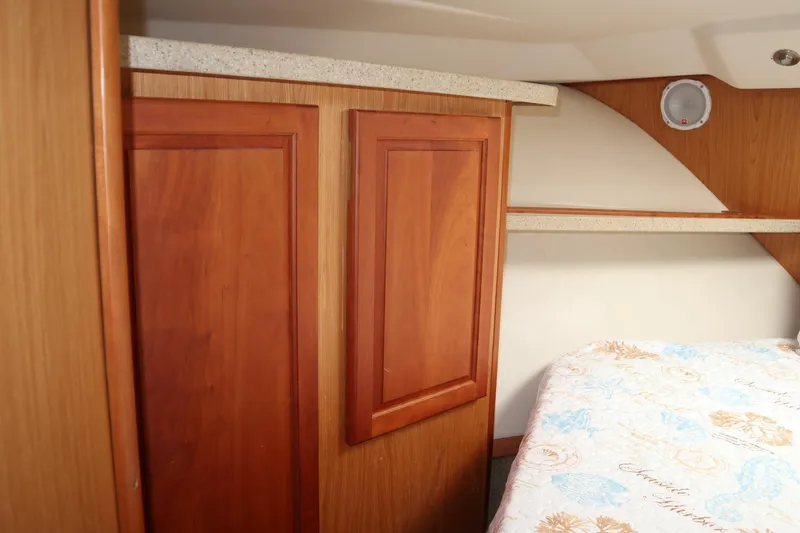  Yacht Photos Pics 2005 Luhrs 38 Convertible cabin interior with wood cabinetry and patterned bedding.
