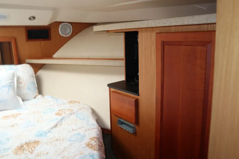  Yacht Photos Pics 2005 Luhrs 38 Convertible cabin interior with wood paneling and cozy bedding.