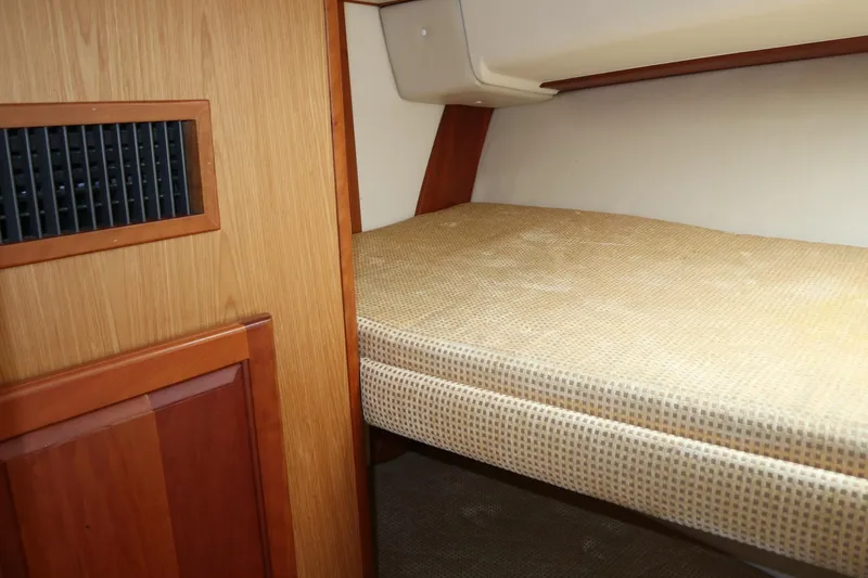  Yacht Photos Pics 2005 Luhrs 38 Convertible cabin interior with wooden paneling and cushioned bed.