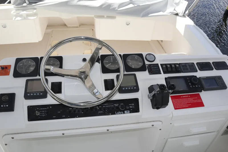  Yacht Photos Pics Control panel of a 2005 Luhrs 38 Convertible boat with steering wheel and navigation instruments.