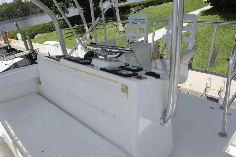  Yacht Photos Pics 2005 Luhrs 38 Convertible boat helm with seating, docked by a scenic riverside.