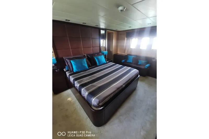  Yacht Photos Pics Luxurious bedroom interior on 2008 Mangusta 80 yacht with striped bedding and teal accents.
