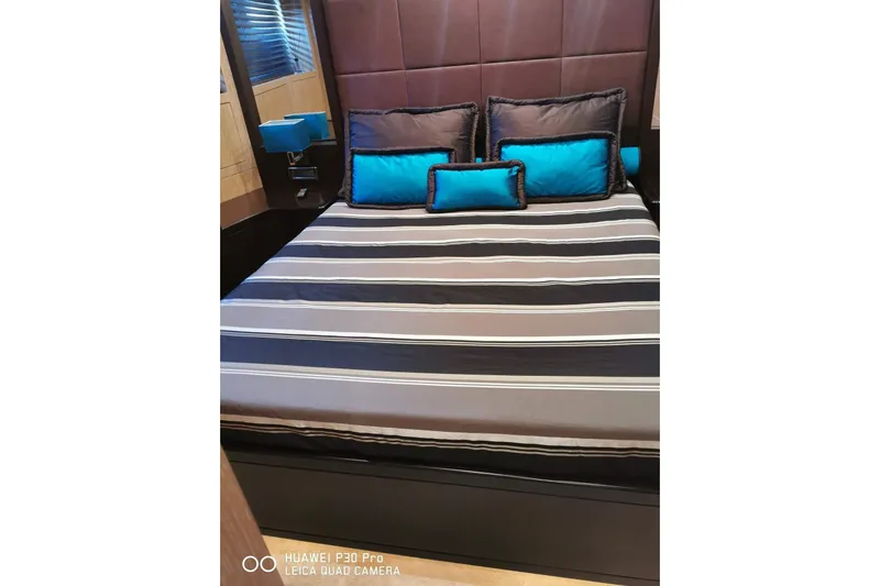 Yacht Photos Pics Luxurious bedroom interior on 2008 Mangusta 80 yacht with striped bedding and blue accents.