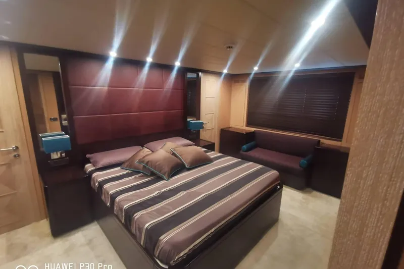  Yacht Photos Pics Luxurious bedroom interior on 2008 Mangusta 80 yacht, featuring elegant design and ambient lighting.