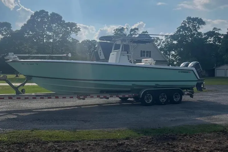  Yacht Photos Pics 2011 Contender 32 ST boat on trailer, parked outdoors near houses and trees.