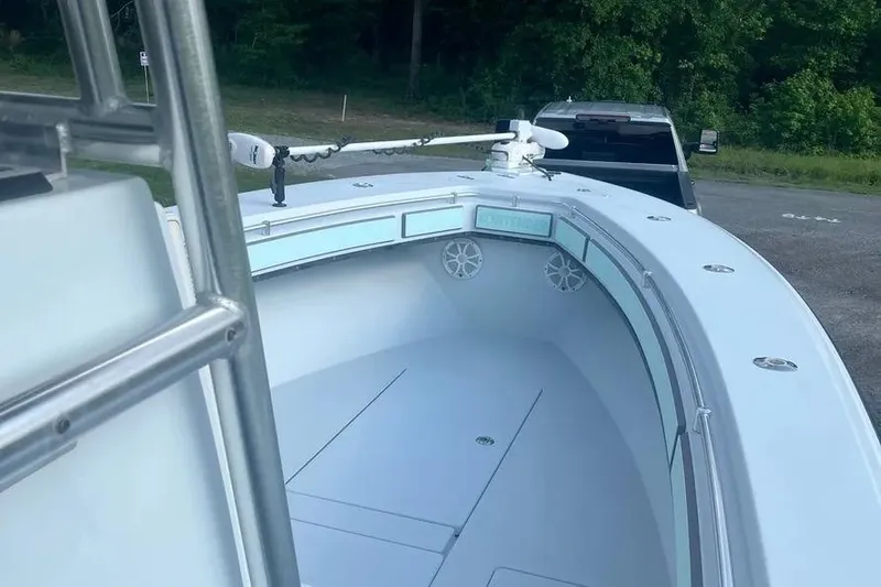  Yacht Photos Pics 2011 Contender 32 ST boat with trolling motor, parked near a forested area.