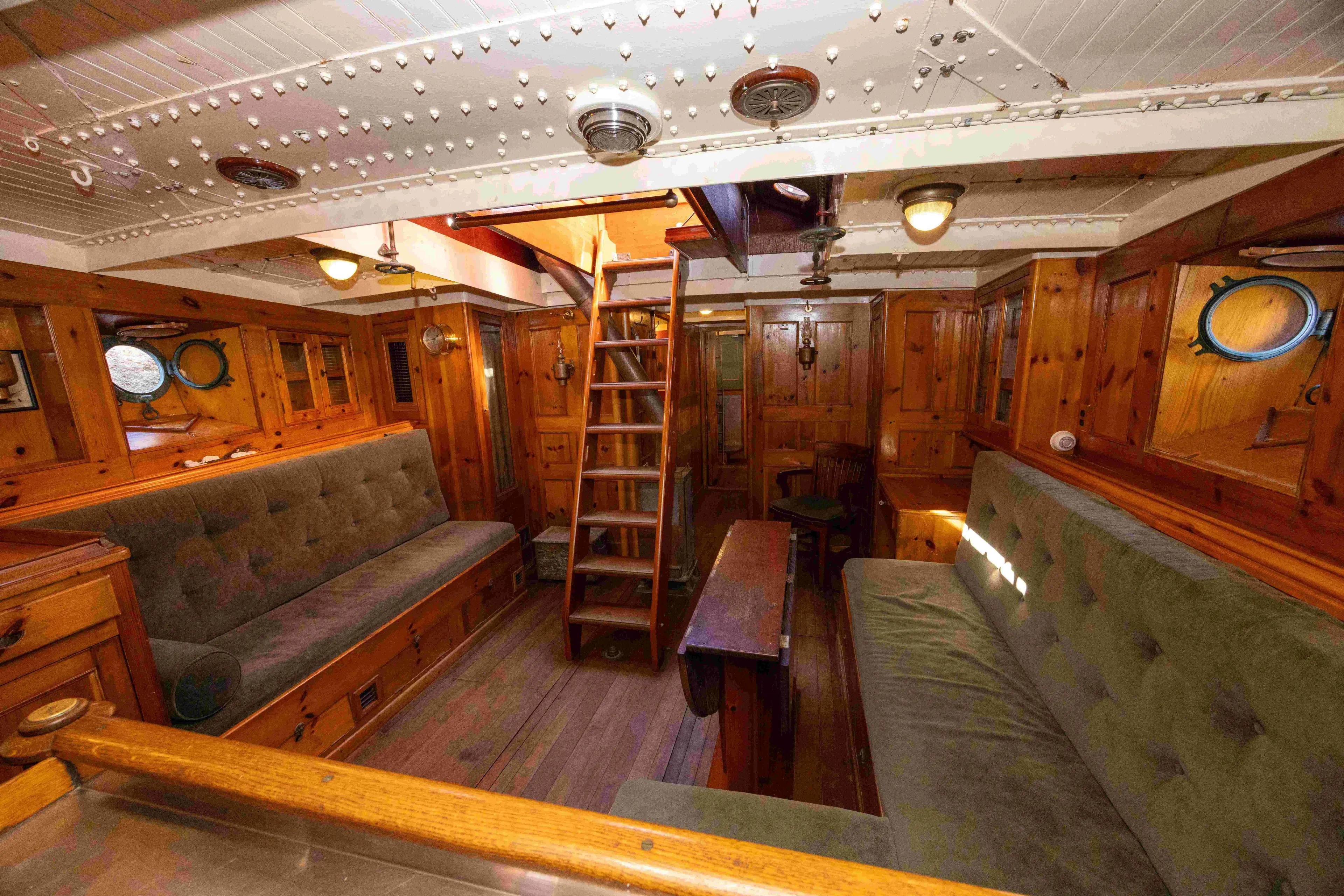 Little Vigilant Yacht Photos Pics Interior of 1950 Abeking & Rasmussen Bespoke Motorsailer Yacht with wooden paneling and seating.