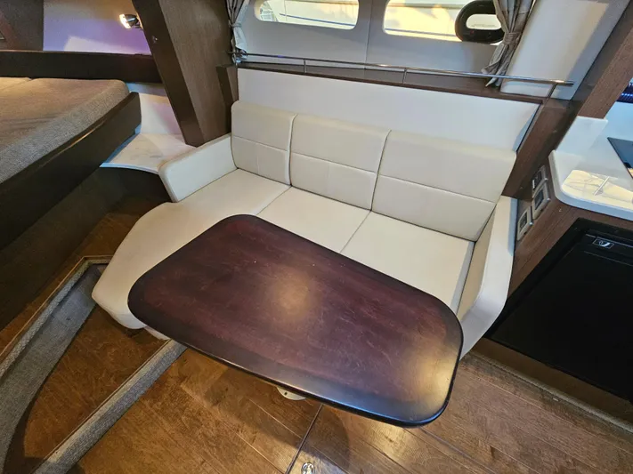 Levon II Yacht Photos Pics Interior of 2017 Sea Ray Sundancer 350 Coupe with seating and wooden table.