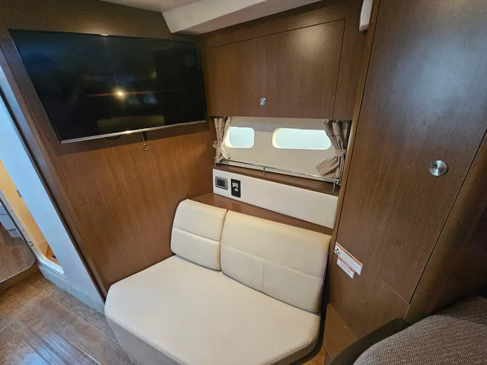 Levon II Yacht Photos Pics 2017 Sea Ray Sundancer 350 Coupe interior with TV, beige seating, and wood paneling.