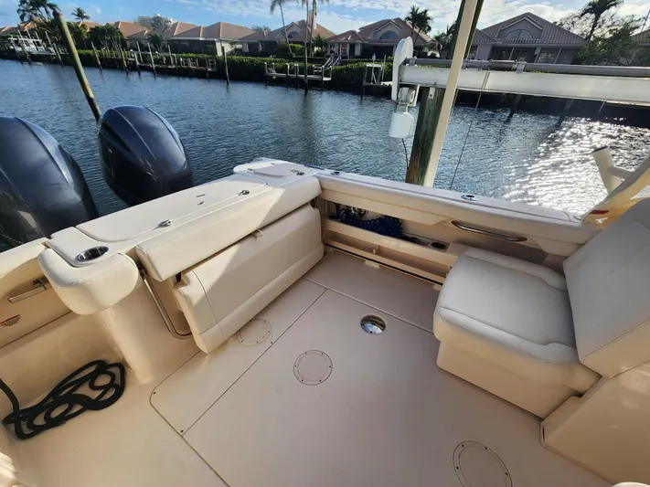  Yacht Photos Pics 2023 Grady-White Freedom 275 boat interior with seating, docked by waterfront homes.