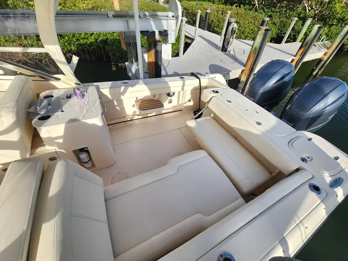  Yacht Photos Pics 2023 Grady-White Freedom 275 boat interior with seating and dual outboard motors at dock.