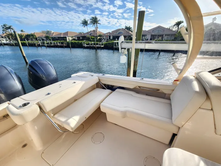 Yacht Photos Pics 2023 Grady-White Freedom 275 boat interior with seating, docked by waterfront homes.
