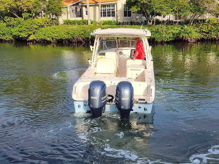  Yacht Photos Pics 2023 Grady-White Freedom 275 boat with dual engines on a calm waterway.