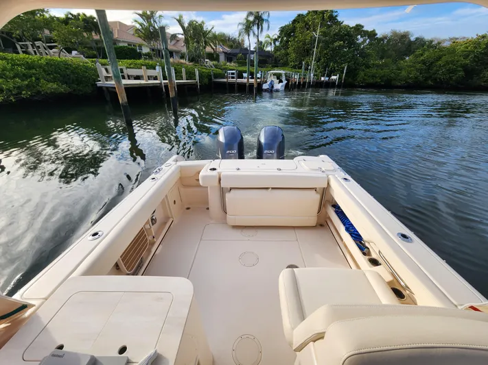  Yacht Photos Pics 2023 Grady-White Freedom 275 boat on calm water, featuring dual outboard engines.