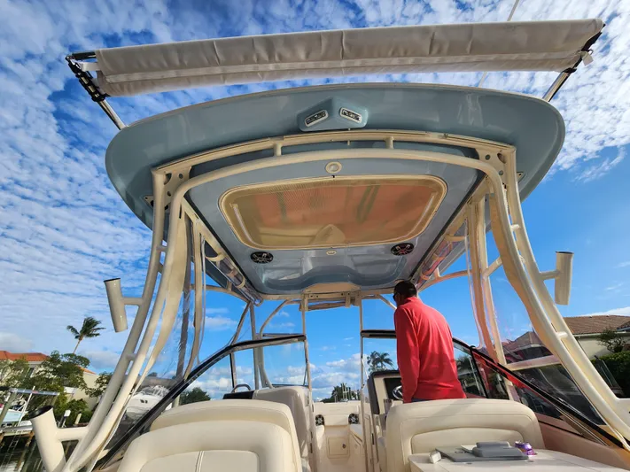  Yacht Photos Pics 2023 Grady-White Freedom 275 boat interior with person, under blue sky.