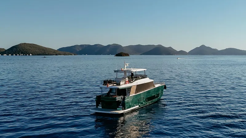  Yacht Photos Pics 2024 Azimut Magellano 66 yacht cruising on serene blue waters with scenic island backdrop.