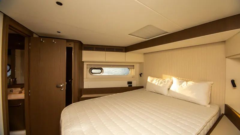  Yacht Photos Pics Luxurious bedroom interior of 2024 Azimut Magellano 66 yacht with elegant design and cozy bedding.