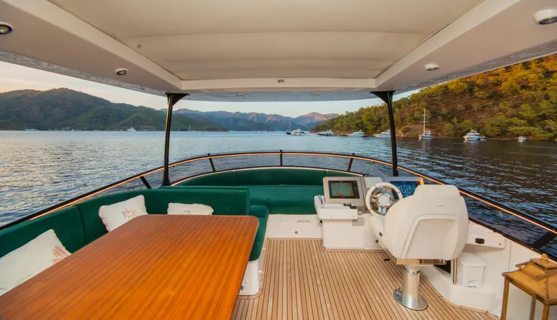  Yacht Photos Pics 2024 Azimut Magellano 66 yacht deck with seating, table, and scenic water view.