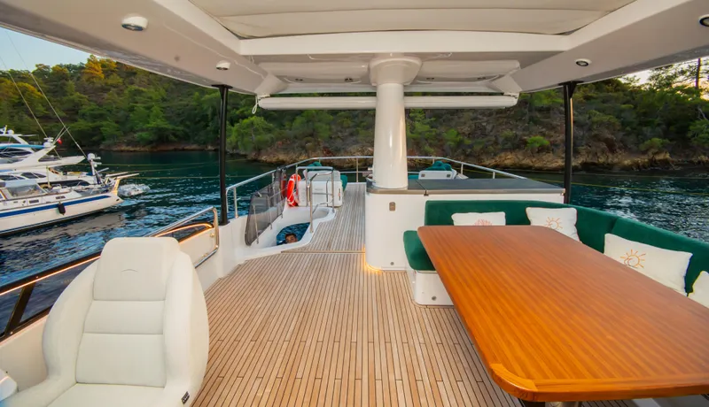  Yacht Photos Pics Luxurious 2024 Azimut Magellano 66 yacht deck with elegant seating and scenic water view.