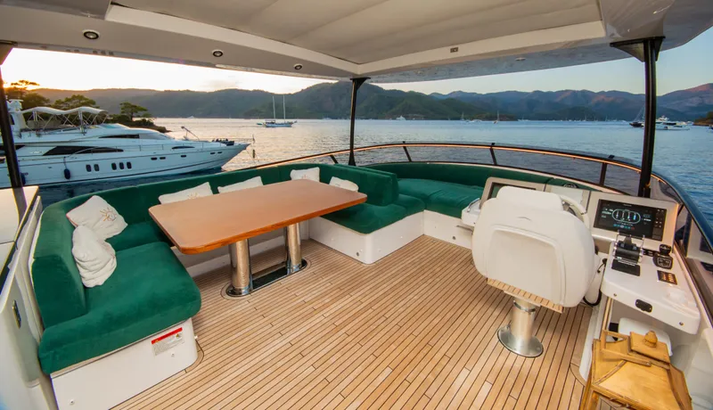  Yacht Photos Pics Luxurious 2024 Azimut Magellano 66 yacht deck with green seating and scenic ocean view.