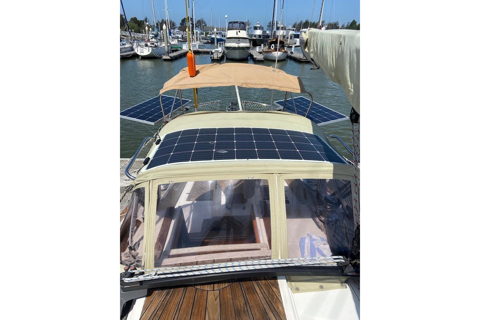 1988 Reliance 44 sailboat with solar panels docked at a marina.