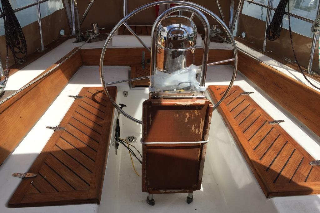Cockpit of 1988 Reliance 44 sailboat with wooden benches and steering wheel.