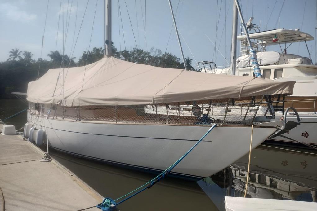 1988 Reliance 44 sailboat docked with protective cover, calm marina setting.