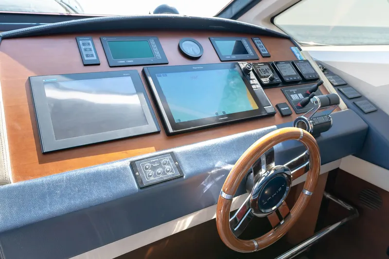 Vea Yacht Photos Pics Control panel of a 2008 Azimut 75 yacht with modern navigation equipment and wooden steering wheel.
