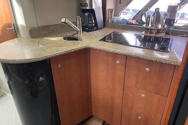  Yacht Photos Pics 2011 Cruisers Yachts 360 Express kitchen with sink, stove, and wooden cabinetry.