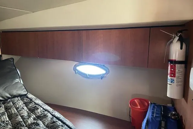  Yacht Photos Pics 2011 Cruisers Yachts 360 Express cabin interior with porthole, fire extinguisher, and storage cabinets.