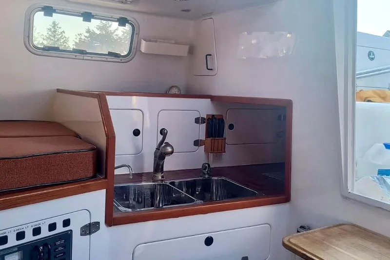 Wingnut Yacht Photos Pics Compact kitchen area in a 2012 Hughes 40 boat, featuring a sink and storage cabinets.