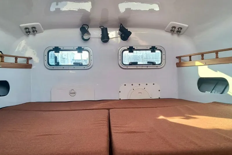 Wingnut Yacht Photos Pics Interior of a 2012 Hughes 40 camper with brown cushions and small windows.